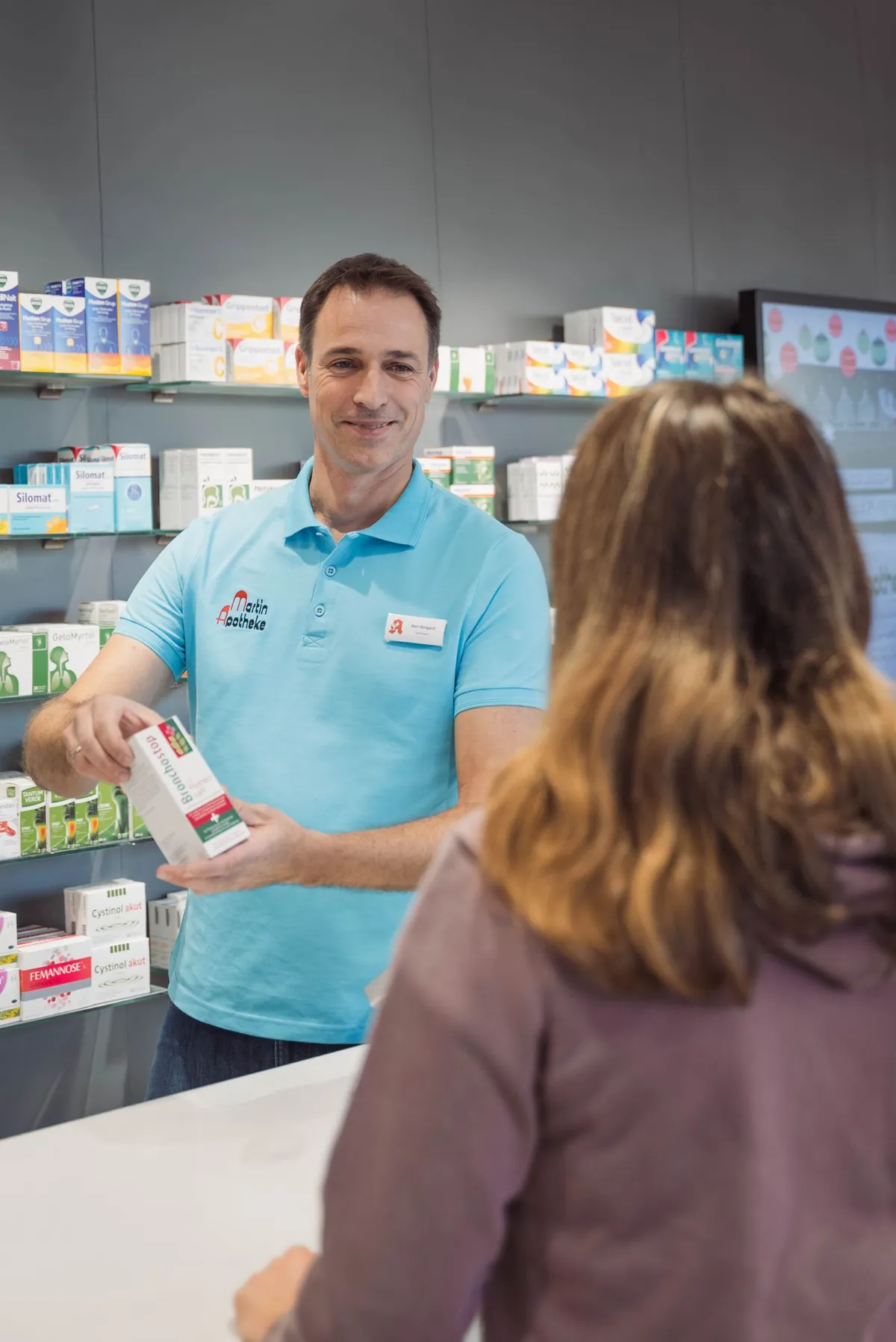 Mitarbeiter der Martin-Apotheke berät eine Kundin.